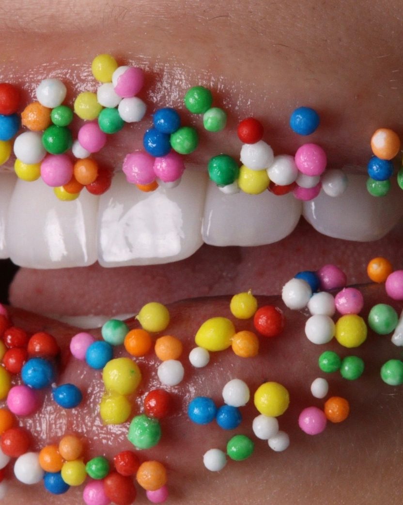 Sonrisa con grageas de colores, de frente