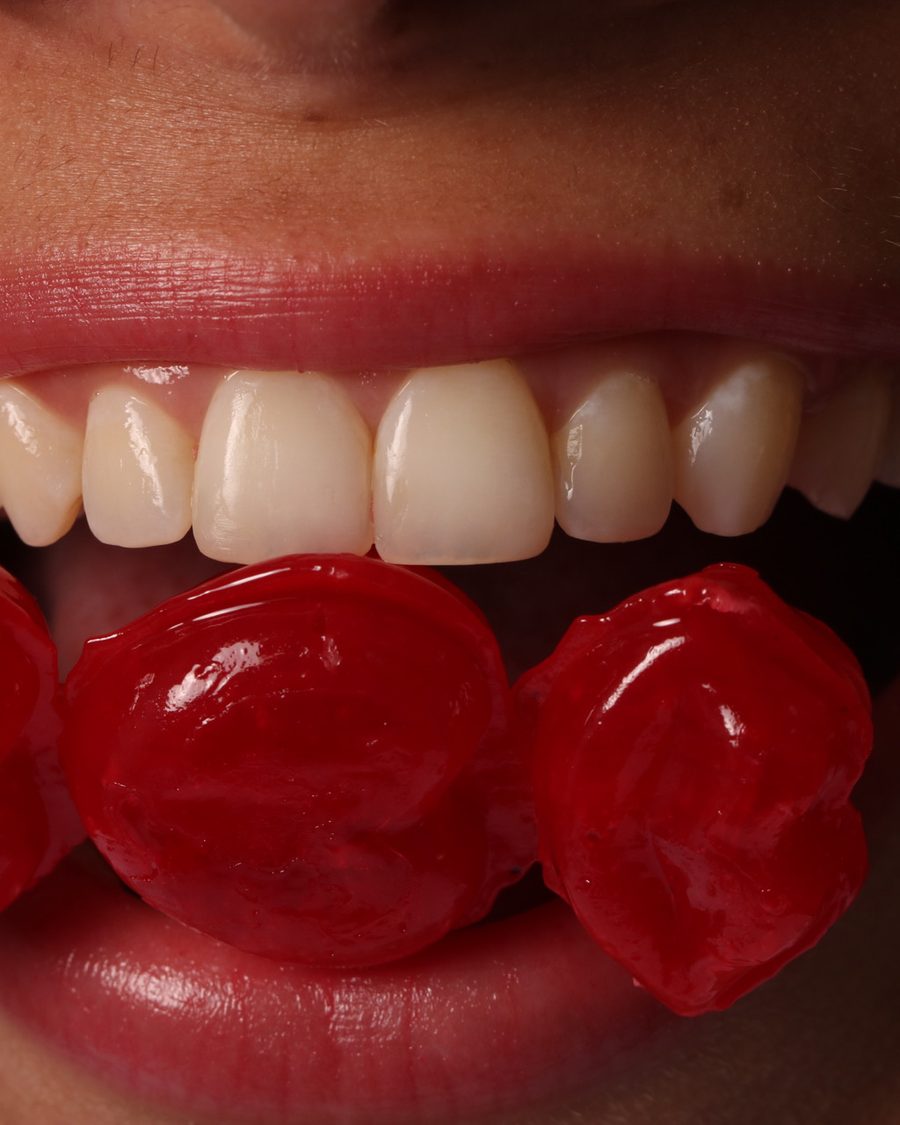 Sonrisa sosteniendo dulces rojos